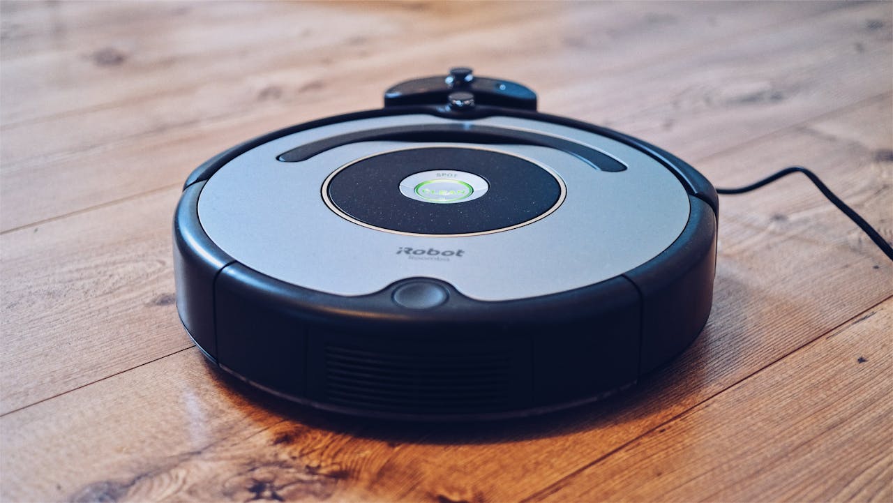 Home Close-up of a robotic vacuum cleaner operating on a hardwood floor, showcasing modern cleaning technology.